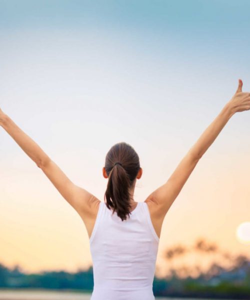 Winning, success and life goals concept. Young woman with arms in the air giving thumbs up.